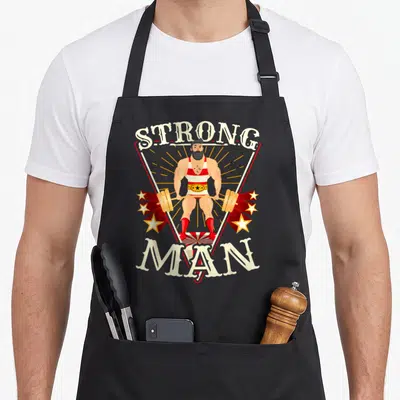 Tablier de cuisine noir avec illustration rétro d'un homme fort tenant une barre de poids encadré par le texte Strong Man.