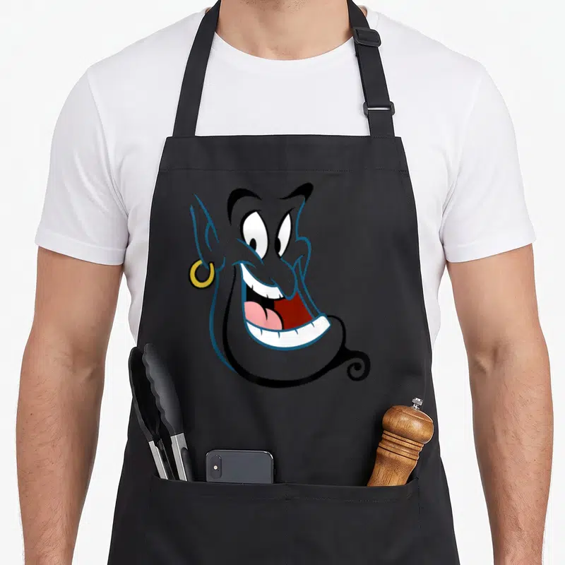 Tablier de cuisine noir avec le visage souriant du Génie bleu portant une boucle d'oreille dorée.