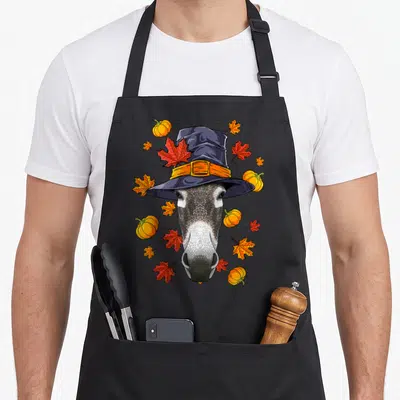 Tablier de cuisine noir avec illustration d'un animal portant un chapeau de pèlerin orné de feuilles d'érable et de pumpkins.