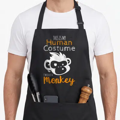Tablier de cuisine noir avec illustration d'un singe blanc et texte orange This is My Human Costume I'm Really A Monkey.