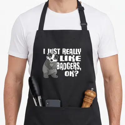 Tablier de cuisine noir avec illustration d'un blaireau debout et texte blanc I Just Really Like Badgers, Ok