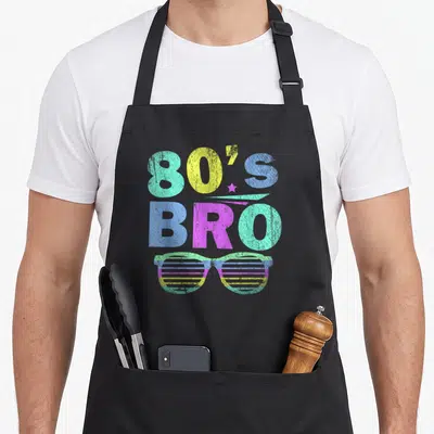 Tablier de cuisine noir avec inscription 80's Bro et lunettes à rayures multicolores style années 80.