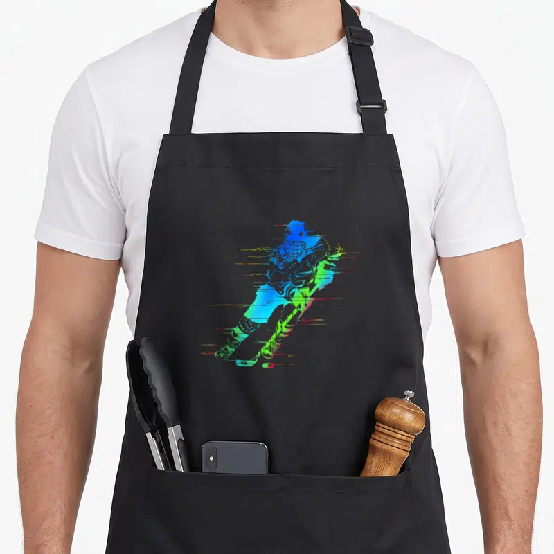Tablier de cuisine noir avec joueur de hockey coloré aux teintes néon et lignes dynamiques évoquant la vitesse.