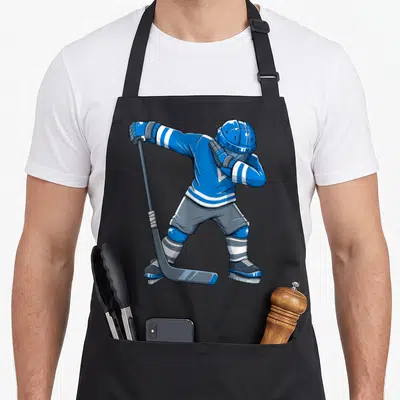Tablier de cuisine noir avec un joueur de hockey en tenue bleue effectuant un dabber avec son bâton.