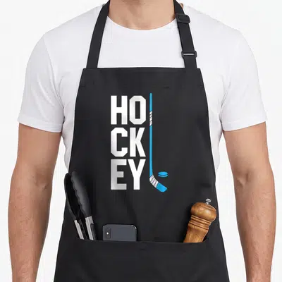 Tablier de cuisine noir avec inscription HOCKEY verticale et crosse bleue stylisée à côté du mot.