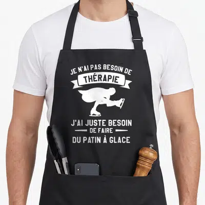 Tablier de cuisine noir avec une silhouette blanche de patineur et le texte Je n'ai pas besoin de thérapie j'ai juste besoin de faire du patin à glace.