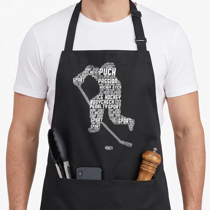 Tablier de cuisine noir avec silhouette de joueur de hockey formée par des mots blancs comme Puck et Sport.