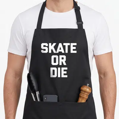 Tablier de cuisine noir avec l'inscription blanche Skate Or Die en gros caractères capitales centrés.
