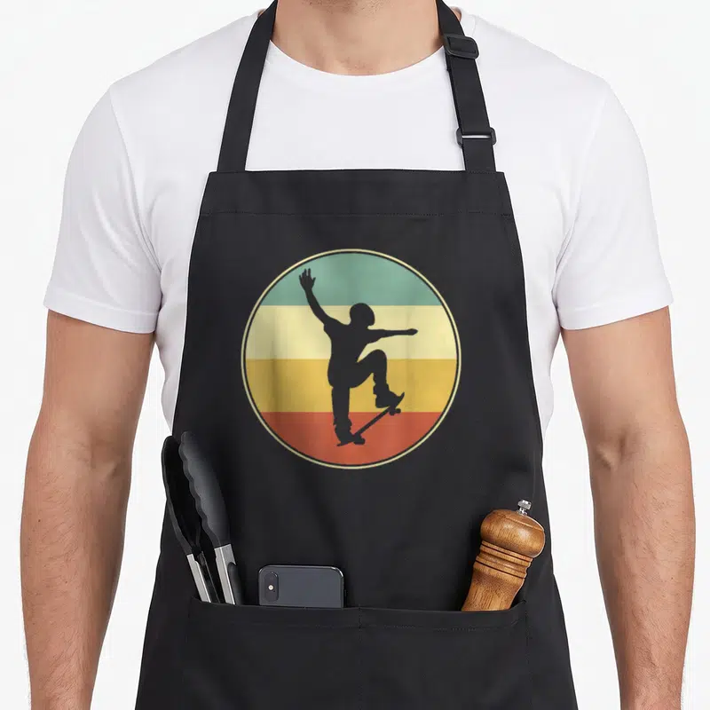 Tablier de cuisine noir avec silhouette de skater sur fond circulaire multicolore style rétro.