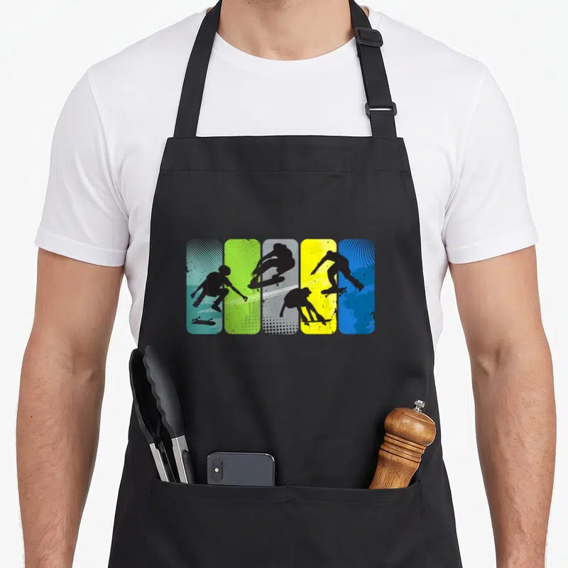 Tablier de cuisine noir avec quatre silhouettes de skaters sur fonds bleu vert jaune et gris texturés.