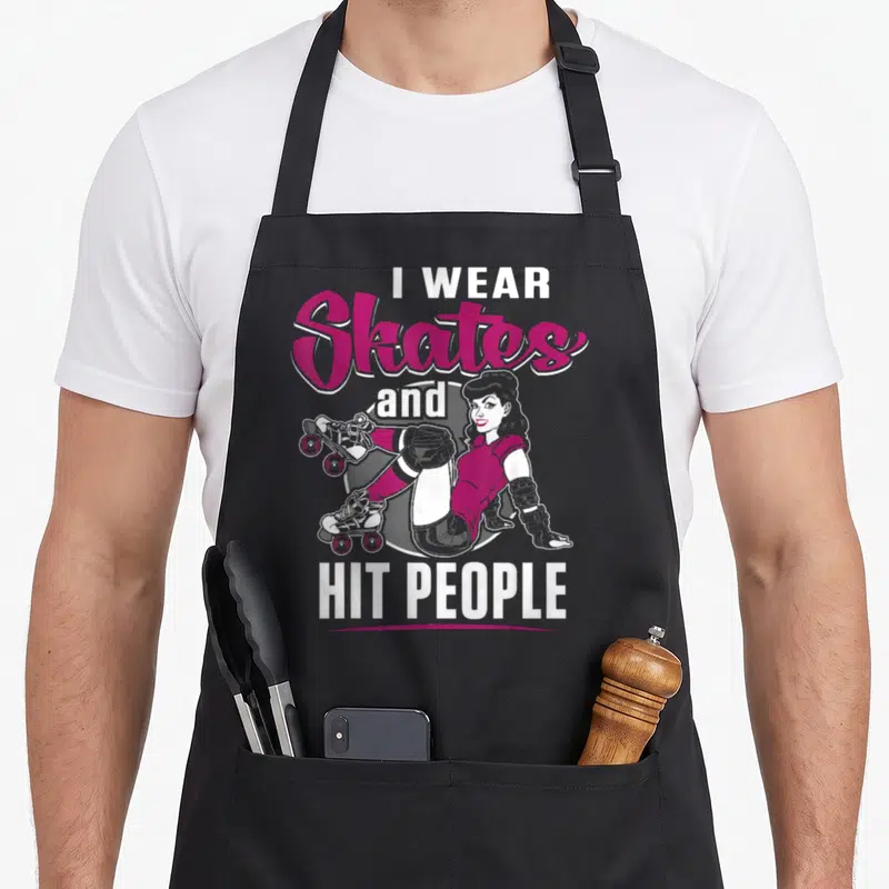 Tablier de cuisine noir avec une illustration de femme en patins et le texte I PORTE Patins et FRAPPE DES GENS en rose et blanc.