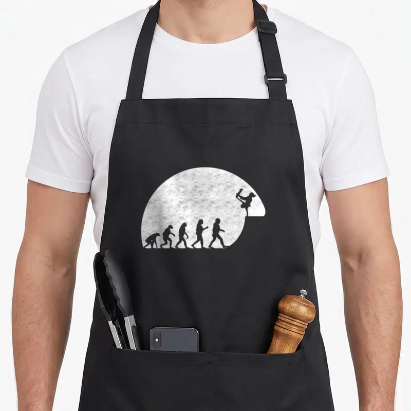 Tablier de cuisine noir avec motif evolution humaine terminant par un skateboarder en air