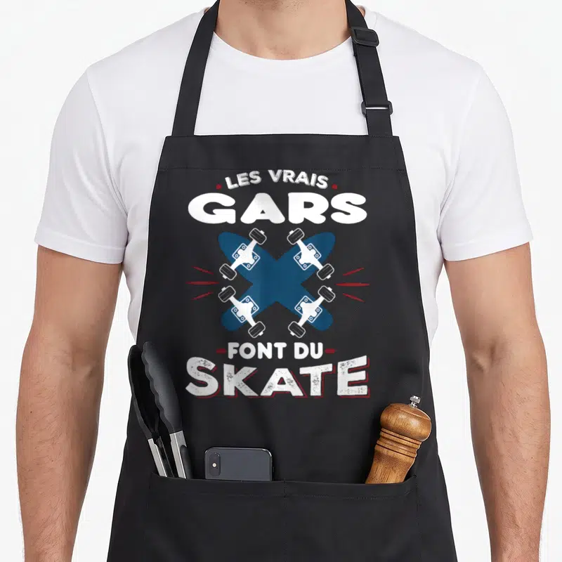 Tablier de cuisine noir avec inscription Les Vrais Gars Font Du Skate et planches de skateboard croisées.