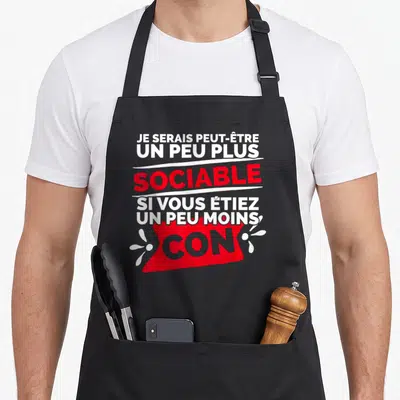 Tablier de cuisine noir avec inscription humoristique blanche et rouge sur fond sombre