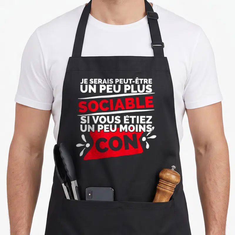 Tablier de cuisine noir avec inscription humoristique blanche et rouge sur fond sombre