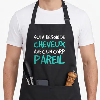 Tablier de cuisine noir avec inscription blanche et turquoise disant qui a besoin de cheveux avec un corp pareil