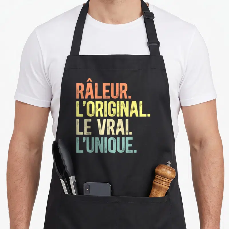 Tablier de cuisine noir avec inscription colorée râleur l'original le vrai l'unique en style vintage dégradé.