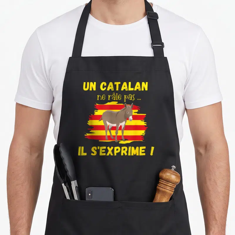Tablier de cuisine noir avec illustration d'un âne sur bandes rouges et jaunes et texte humoristique en jaune.