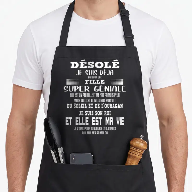 Tablier de cuisine noir portant une citation blanche sur l'amour d'un couple et une partenaire géniale.