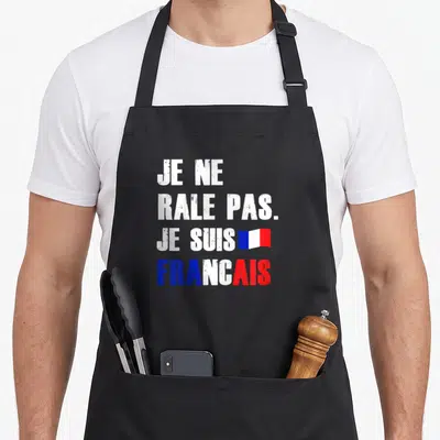 Tablier de cuisine noir avec l'inscription je ne râle pas je suis français en blanc et les couleurs du drapeau tricolore.