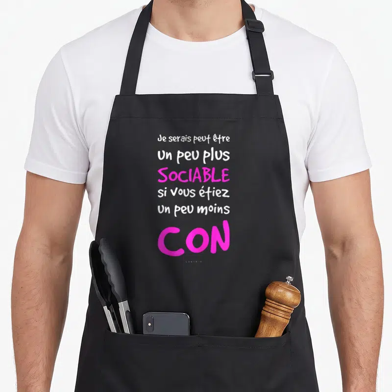 Tablier de cuisine noir avec une citation humoristique en blanc et rose vif sur fond uni.
