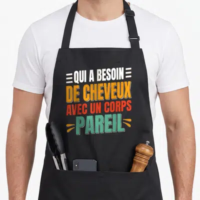 Tablier de cuisine noir avec l'inscription colorée Qui a besoin de cheveux avec un corps pareil en typographie moderne.