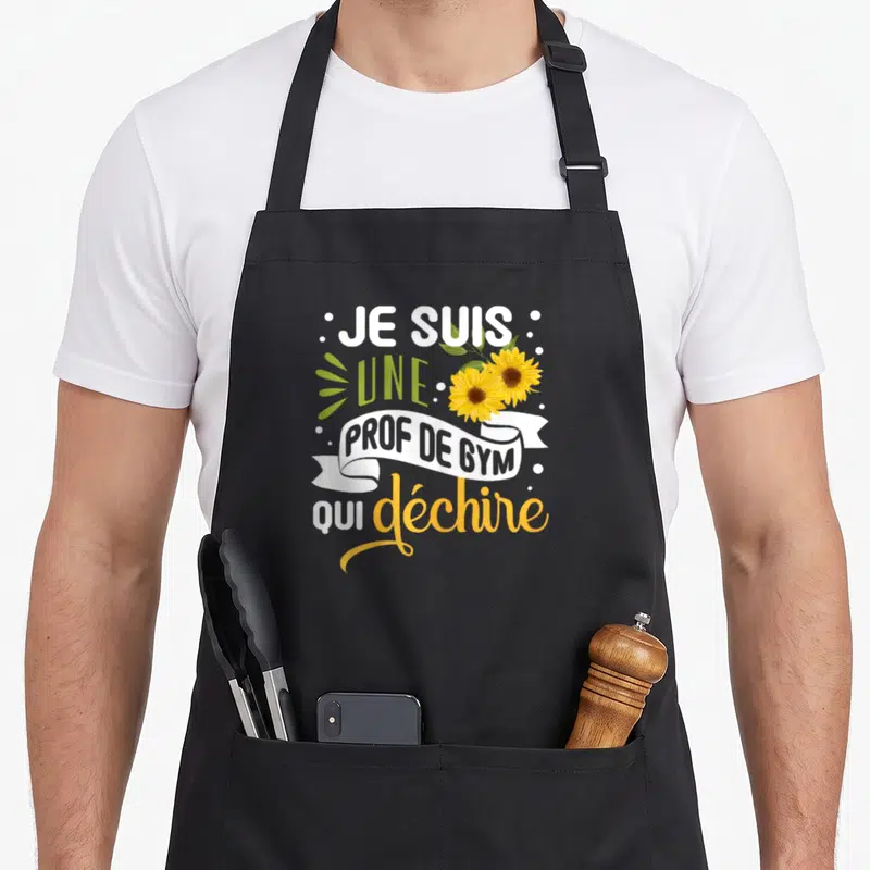 Tablier de cuisine noir avec inscription Je suis une prof de gym qui déchire et deux tournesols jaunes.