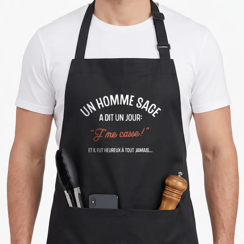 Tablier de cuisine noir avec l'inscription Un homme sage a dit J me casse en blanc et orange.