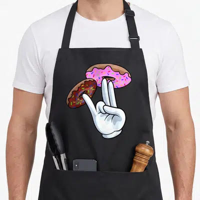 Tablier de cuisine noir avec main blanche tenant deux beignets colorés et une paille en plastique.