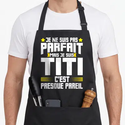 Tablier de cuisine noir avec le texte blanc et jaune Je ne suis pas parfait mais je suis Titi c'est presque pareil