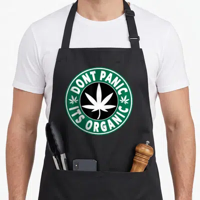 Tablier de cuisine noir avec logo rond vert Dont Panic Its Organic et feuille de cannabis blanche centrale.