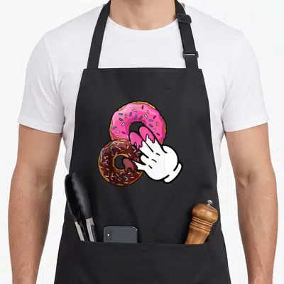 Tablier de cuisine noir avec illustration de deux donuts colorés et une main blanche stylisée tenant le sucré.