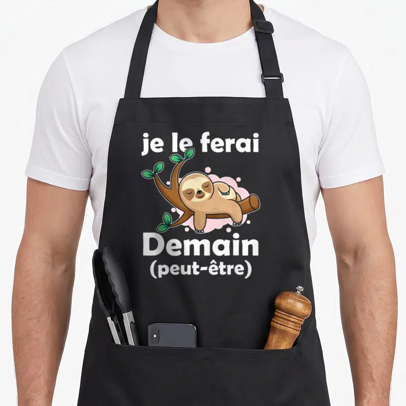 Tablier de cuisine noir avec un fourreau dormant et le texte je le ferai demain peut-être en blanc.