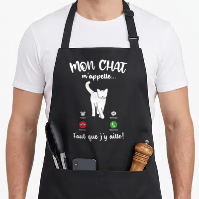 Tablier de cuisine noir avec illustration blanche d'un chat et interface téléphone imitant une notification de rappel.