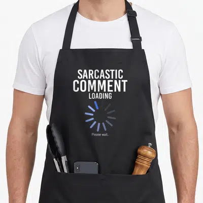 Tablier de cuisine noir avec texte blanc sarcastic comment loading et cercle de chargement bleu.