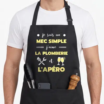 Tablier de cuisine noir avec texte jaune et blanc sur la plomberie et l'apéro, illustré par une clé et deux verres.