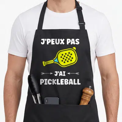 Tablier de cuisine noir avec illustration raque jaune et texte blanc jai pickleball