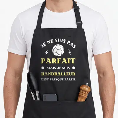 Tablier de cuisine noir avec texte blanc et jaune Je ne suis pas parfait mais je suis handballeur c'est presque pareil autour d'un ballon.