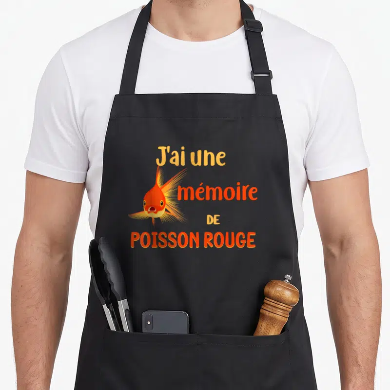Tablier de cuisine noir avec illustration d'un poisson rouge orange et le texte J'ai une mémoire de poisson rouge imprimé en lettres colorées.