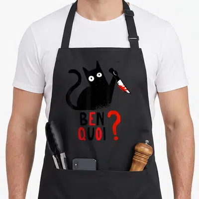 Tablier de cuisine noir avec un chat noir tenant un couteau et le texte ben quoi en rouge et noir.