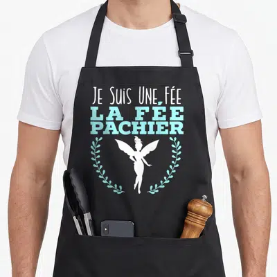 Tablier de cuisine noir avec inscription Je suis une fée la fée pachier et silhouette de fée encadrée de branches turquoise.