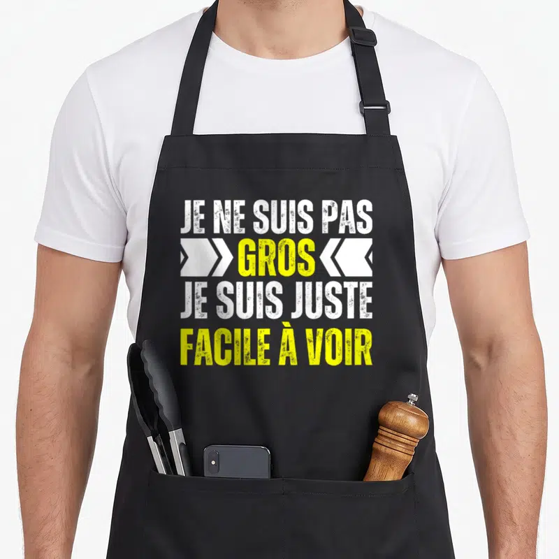 Tablier de cuisine noir avec texte blanc et jaune disant je ne suis pas gros je suis juste facile à voir