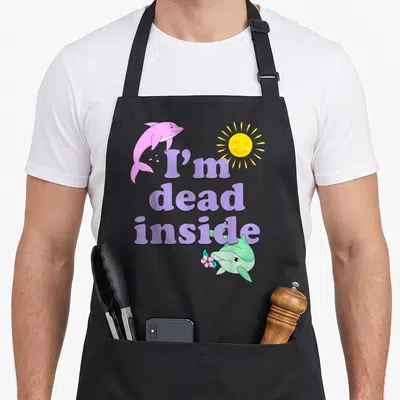 Tablier de cuisine noir avec deux dauphins colorés, un soleil jaune et le texte I'm dead inside en violet.