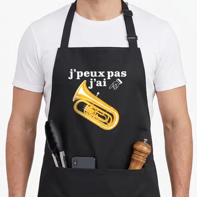 Tablier de cuisine noir avec illustration tuba jaune et texte blanc j'peux pas j'ai accompagnés d'une main pointant vers l'instrument.