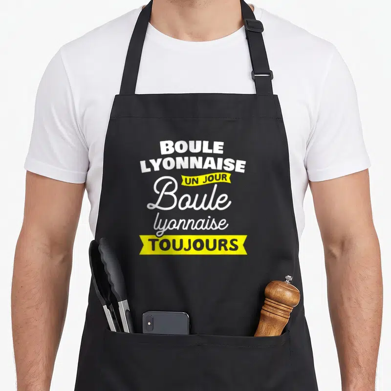 Tablier de cuisine noir avec l'inscription boule lyonnaise un jour toujours en blanc et jaune.