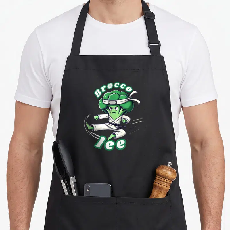 Tablier de cuisine noir avec illustration d'un brocoli en tenue de karaté et le texte Brocco Lee.