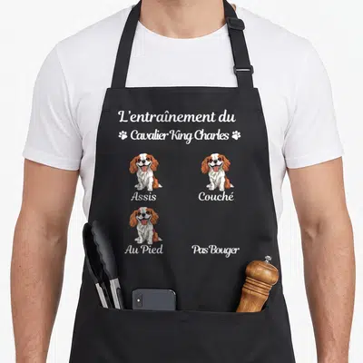 Tablier de cuisine noir avec illustration d'un chien cavalier king charles et les mots assis couché au pied pas bouger