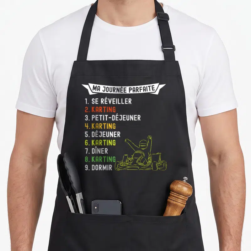 Tablier de cuisine noir avec liste humoristique Ma Journée Parfaite et dessin de pilote de kart en jaune vert.