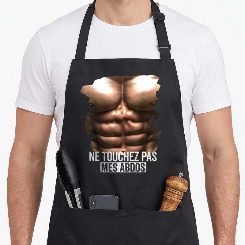 Tablier de cuisine noir avec illustration de torse musclé et texte ne touchez pas mes abdos imprimé en blanc.
