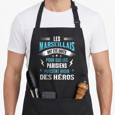Tablier de cuisine noir avec typographie bleue et blanche Les Marseillais ont été créés pour que les Parisiens puissent avoir des héros.